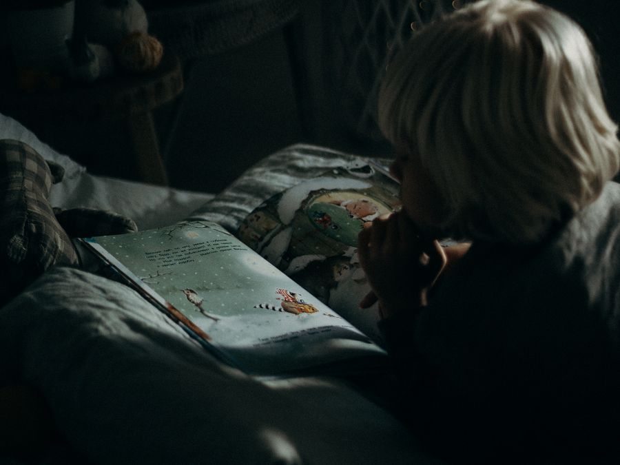 Niño leyendo un libro con atención